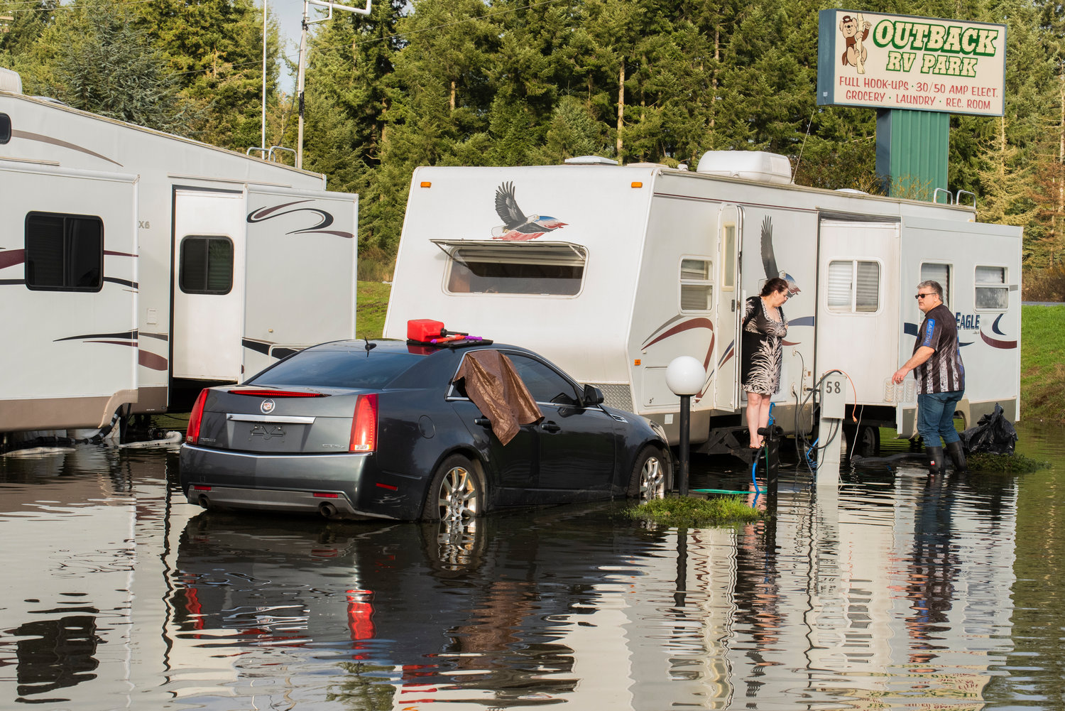 Steve and Mika Weathers step outside their mobile trailer to gather items and access damage to two vehicles that had water in them at the Outback R.V. Park in Rochester on Saturday.
