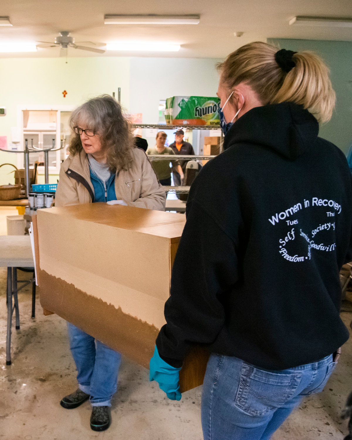 Water damage is seen on donated furniture as it is carried through Lewis County Gospel Mission Monday in Chehalis.