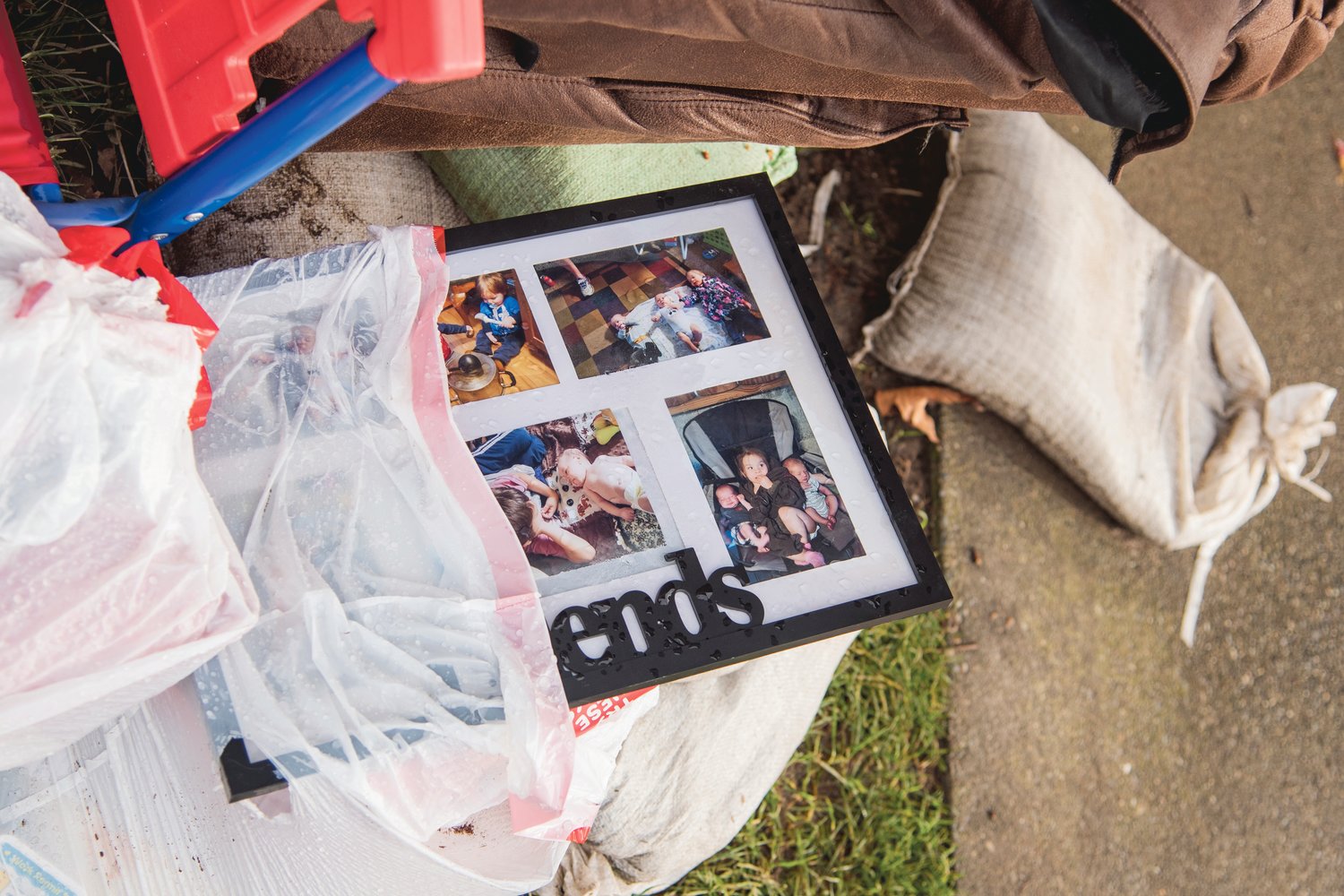 Pictures sit among the remains of damaged furniture on top of sandbags outside the Chehalis Avenue Apartments on Wednesday.