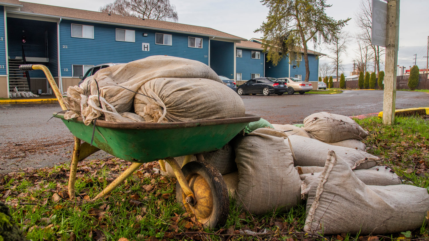 Sandbags sit in a wheelbarrow outside the Chehalis Avenue Apartments after multiple lower level apartments flooded.