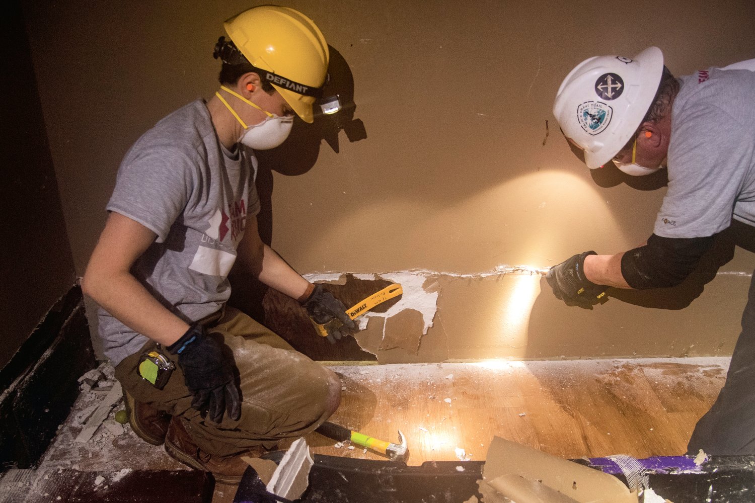 Team Rubicon volunteers help the Pardue family by removing drywall damaged by flood waters inside their pantry Sunday morning.