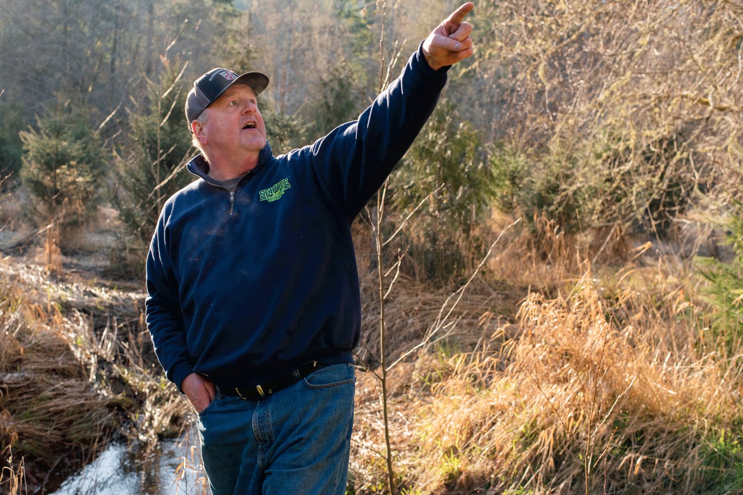 Bob Russell points out trees he has tried to protect from beaver in the past on his property off Jeffries Road near Adna.