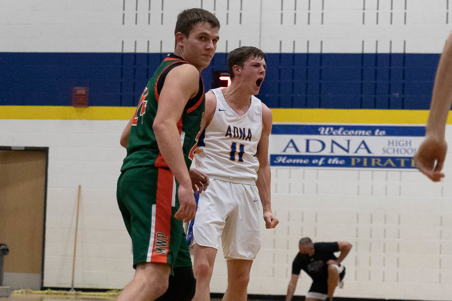 Adna guard Chase Collins celebrates after a critical 3-pointer as MWP's Carter Dantinne looks back Jan. 28.