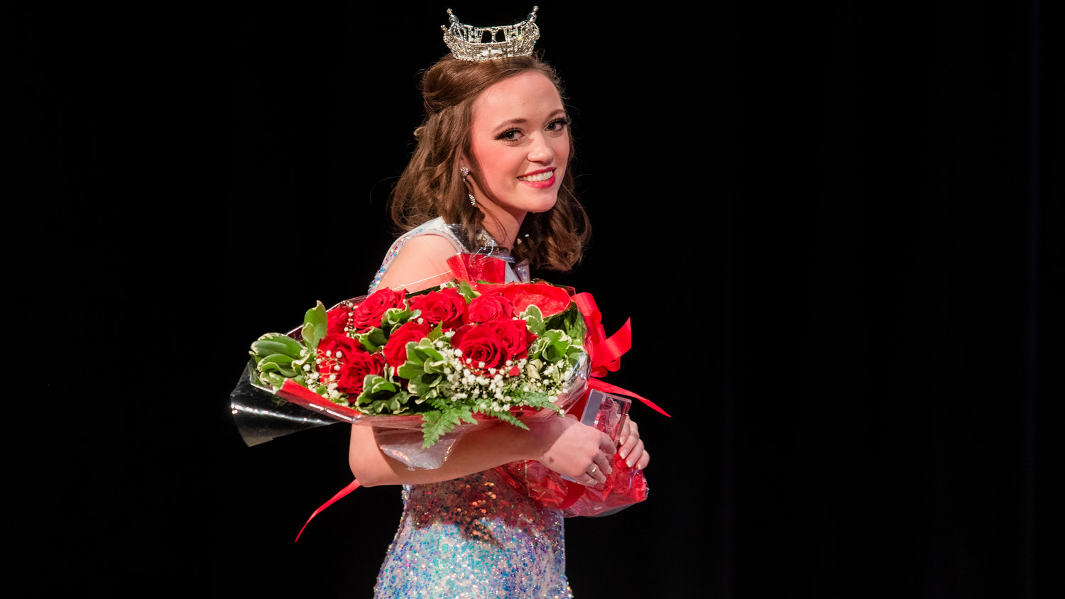 Briana Rasku holds flowers and awards while walking off stage after being crowned Miss Lewis County during an event held at Centralia High School Saturday night.