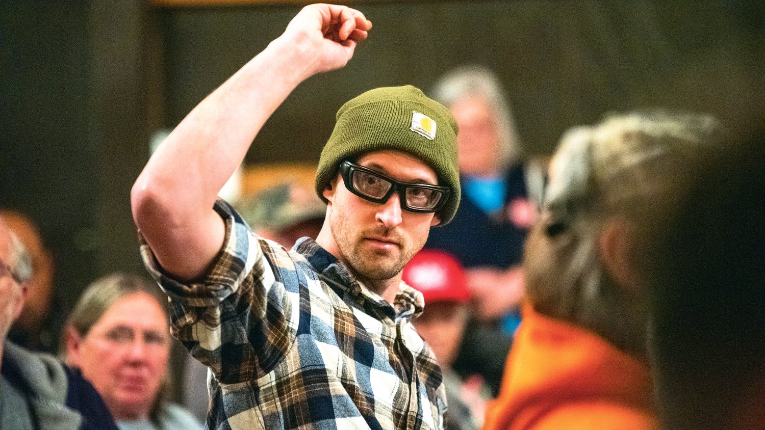 A man from Tacoma raises his hand at a Wednesday night Joe Kent town hall in Onalaska. He refused to reveal his name to The Chronicle but confirmed he was at the event in support of Nick Fuentes, a rising far-right figure who Kent recently denounced due to Fuentes’s anti-semitism, Kent said Wednesday.