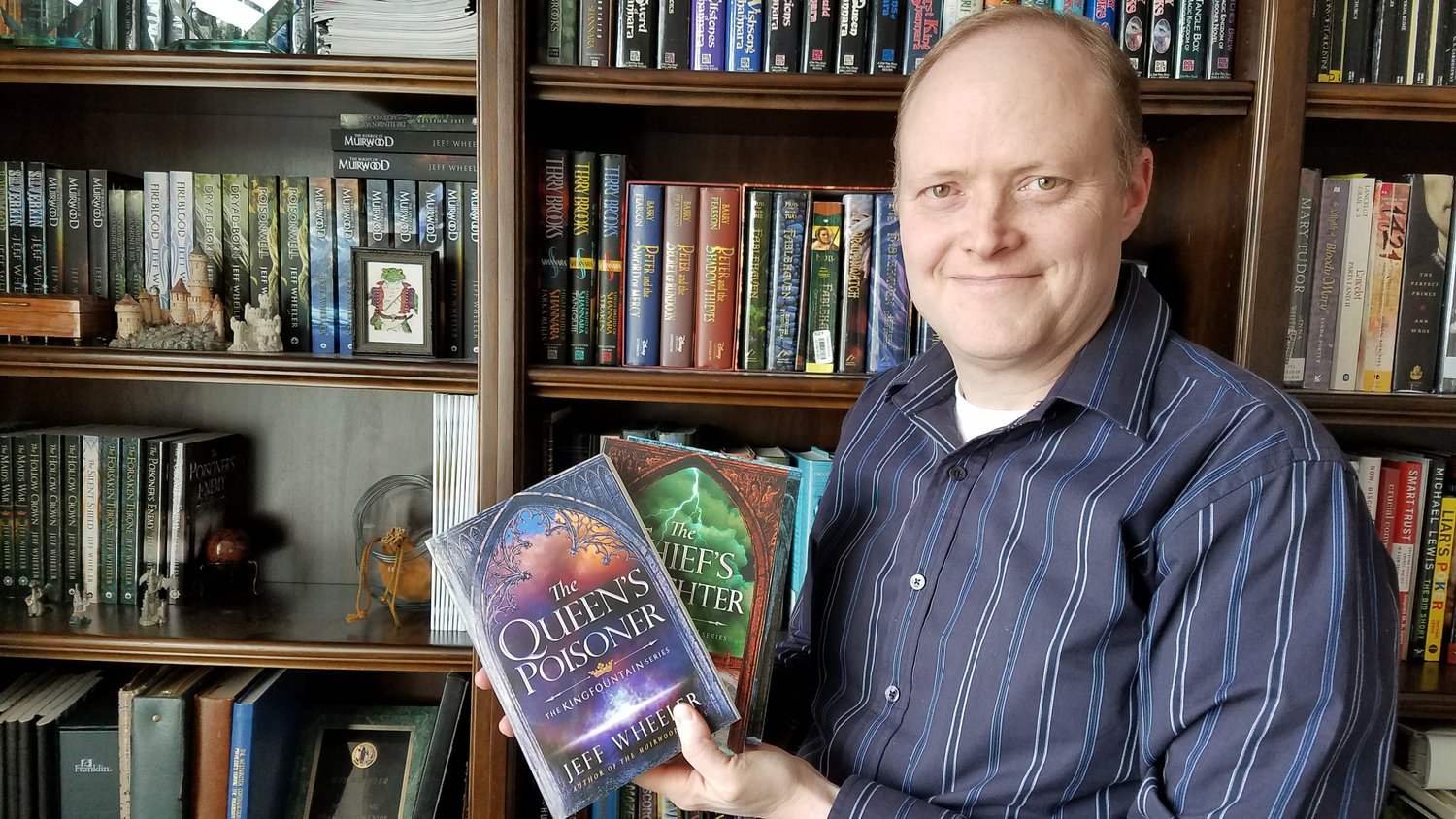 Author Jeff Wheeler is pictured with a pair of his books.