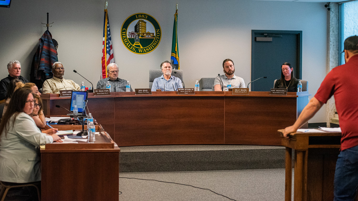 FILE PHOTO — City council members listen to attendees speak at the podium during a meeting in Chehalis.