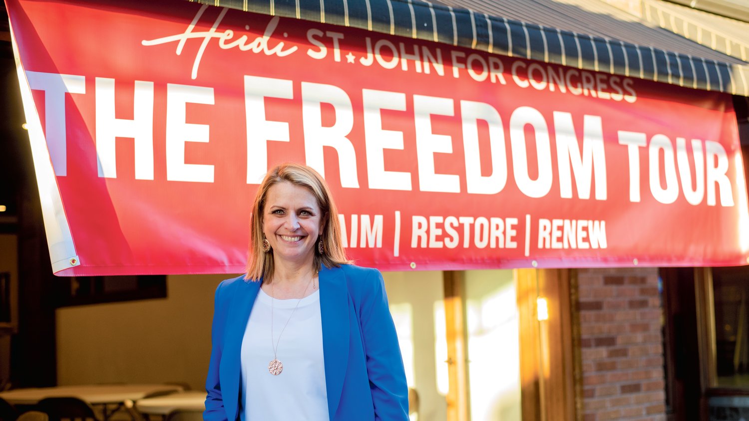 Heidi St. John smiles for a photo in front of “The Freedom Tour” banner Tuesday afternoon in downtown Centralia.