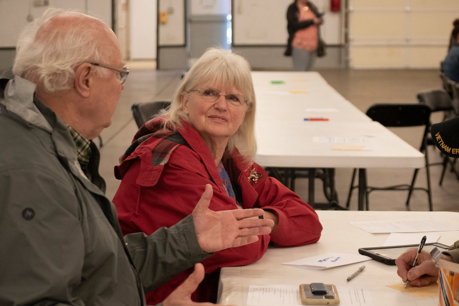 Larry McGee and Merry Hart discuss pros and cons of a proposed night-by-night shelter in Lewis County during a public forum on Thursday night at the Southwest Washington Fairgrounds.