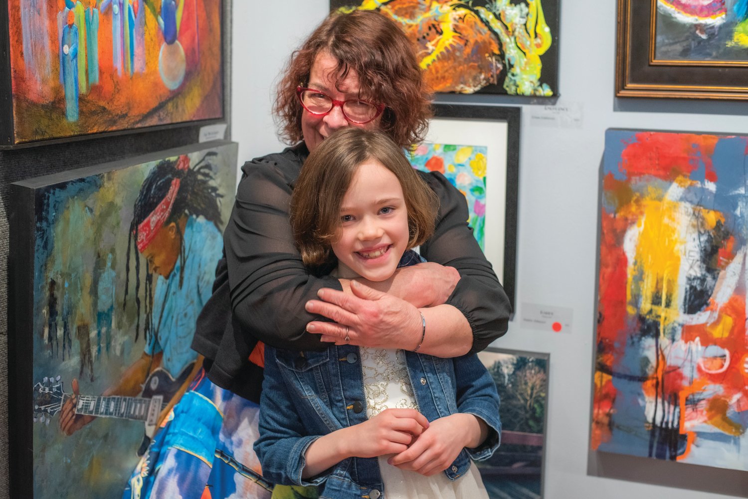 Jan Nontell, owner of the Rectangle Gallery, embraces Haddie Althauser as she sells a work of art Friday in Centralia.
