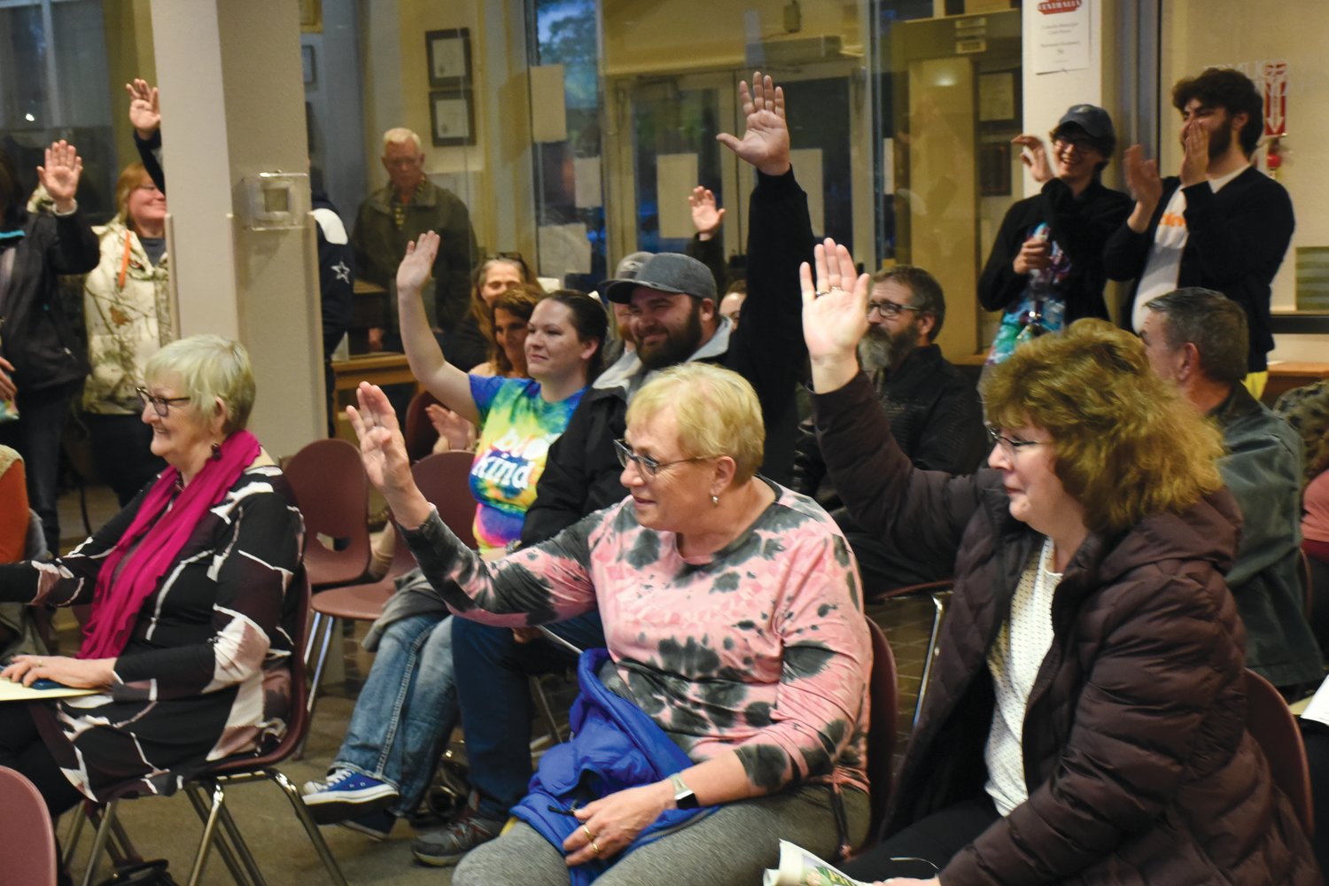 Community Members raise their hands in support of the Allee family as they asked the Centralia City Council to lease a concession building in Rotary Riverside Park to their skate shop Tuesday in an attempt to realize the dreams of Braden Allee, 21, who was severely brain-damaged in a 2019 longboarding accident.