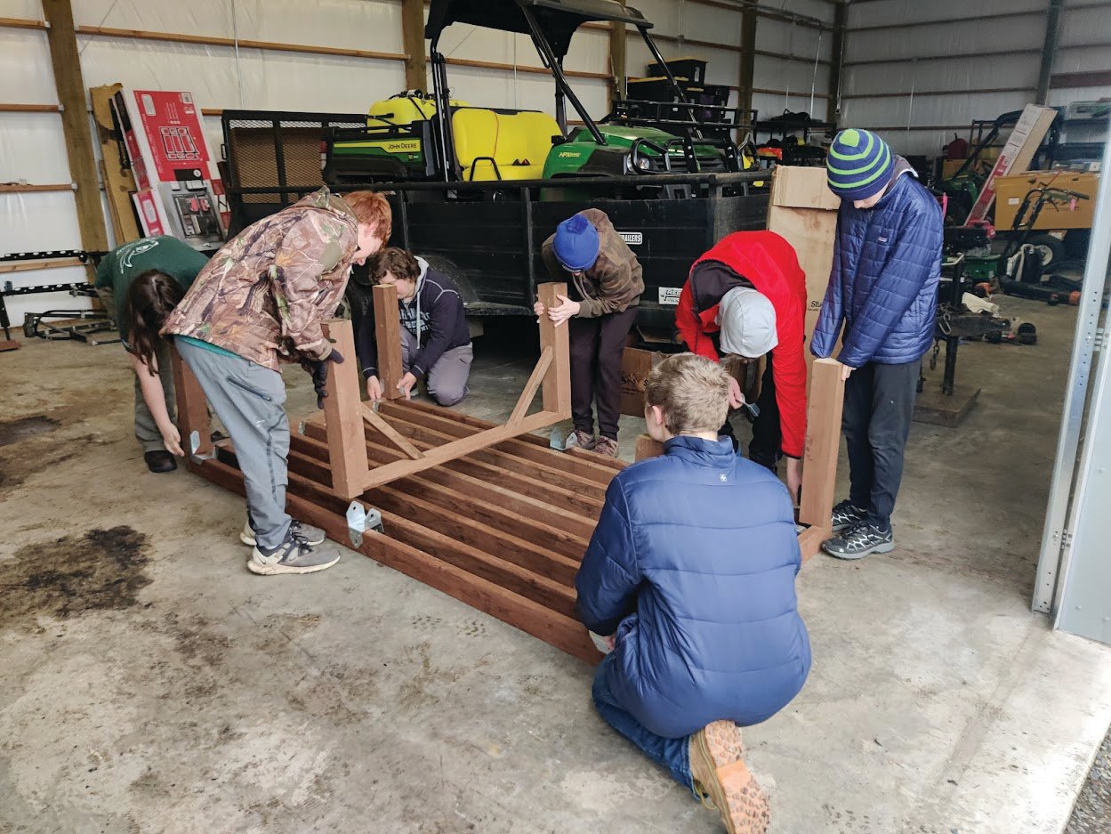 Boy Scout Jesse Ervin and others assemble table to be installed at the Scatter Creek Wildlife Area.