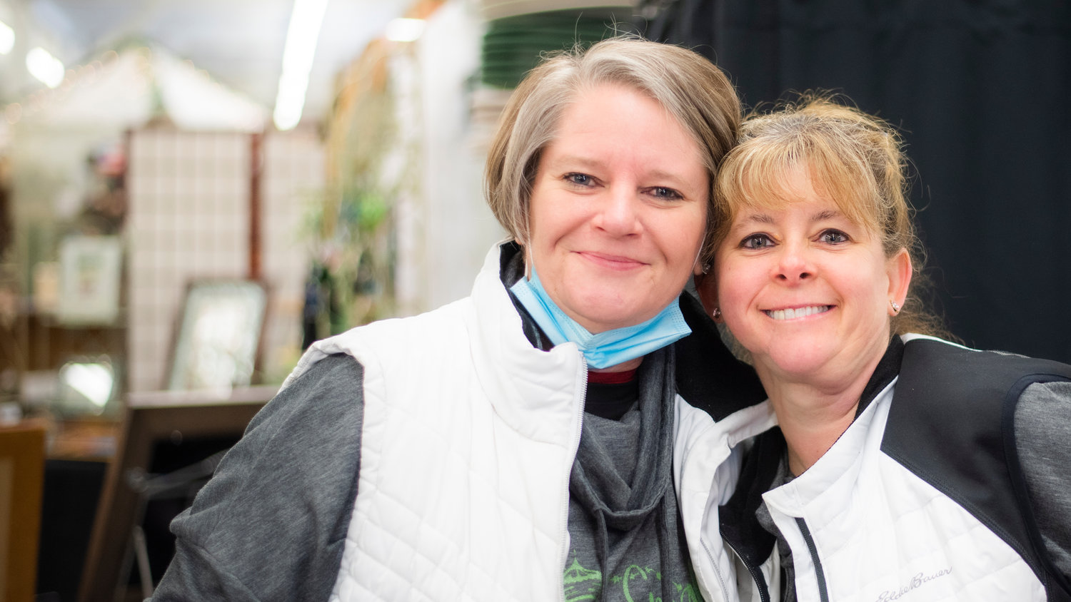 Julie Wiseman and Teresa Berg smile for a photo under the grandstands at the Southwest Washington Fairgrounds during the Country Chicks Spring Show.