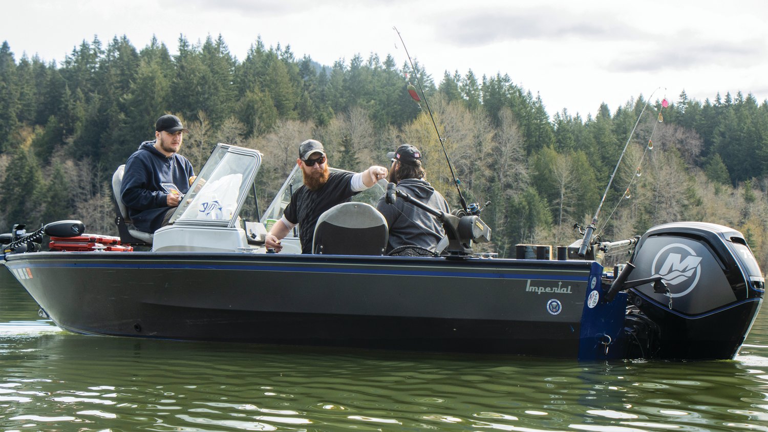 Boaters gesture towards equipment during the Mineral Lake Fishing Derby Saturday morning.