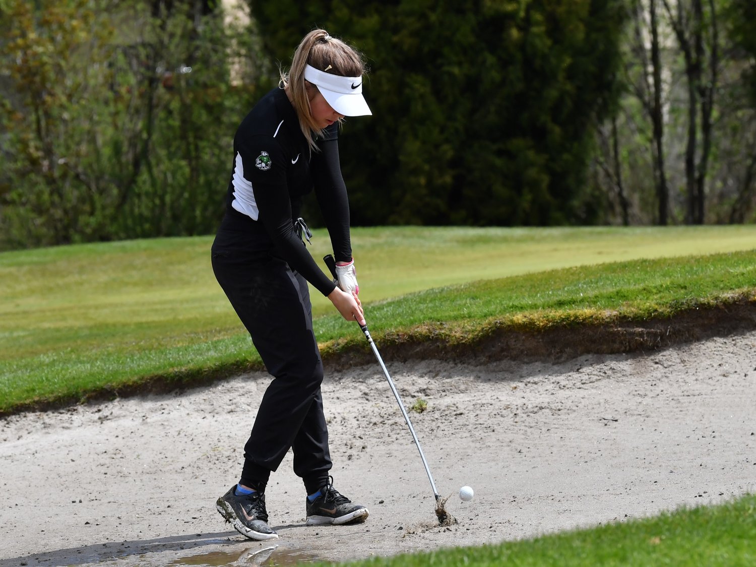 Tumwater junior Sammie Jasper chips the ball out of the bunker on the ninth hole, at the Cowlitz Invitational at Mint Valley on April 27.