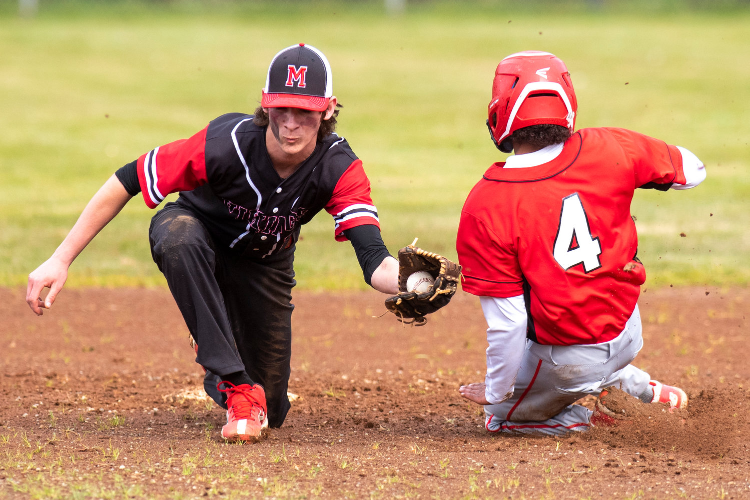 Mossyrock shortstop Gunner Mulligan, left, catches a throw to second as an Oakville baserunner slides into second base during a game in Chehalis VIllage on April 28.