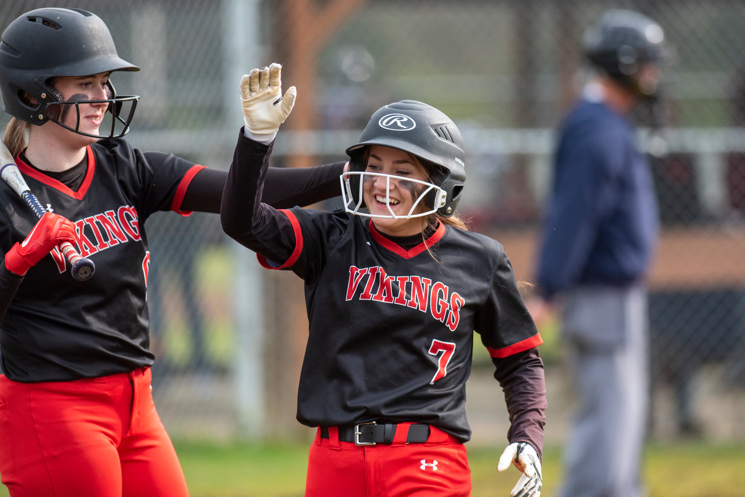 Mossyrock's Jolee Hadaller, left, congratulates Lois Stone (7) after Stone scored a run against Oakville during a game in Chehalis Village on April 28.