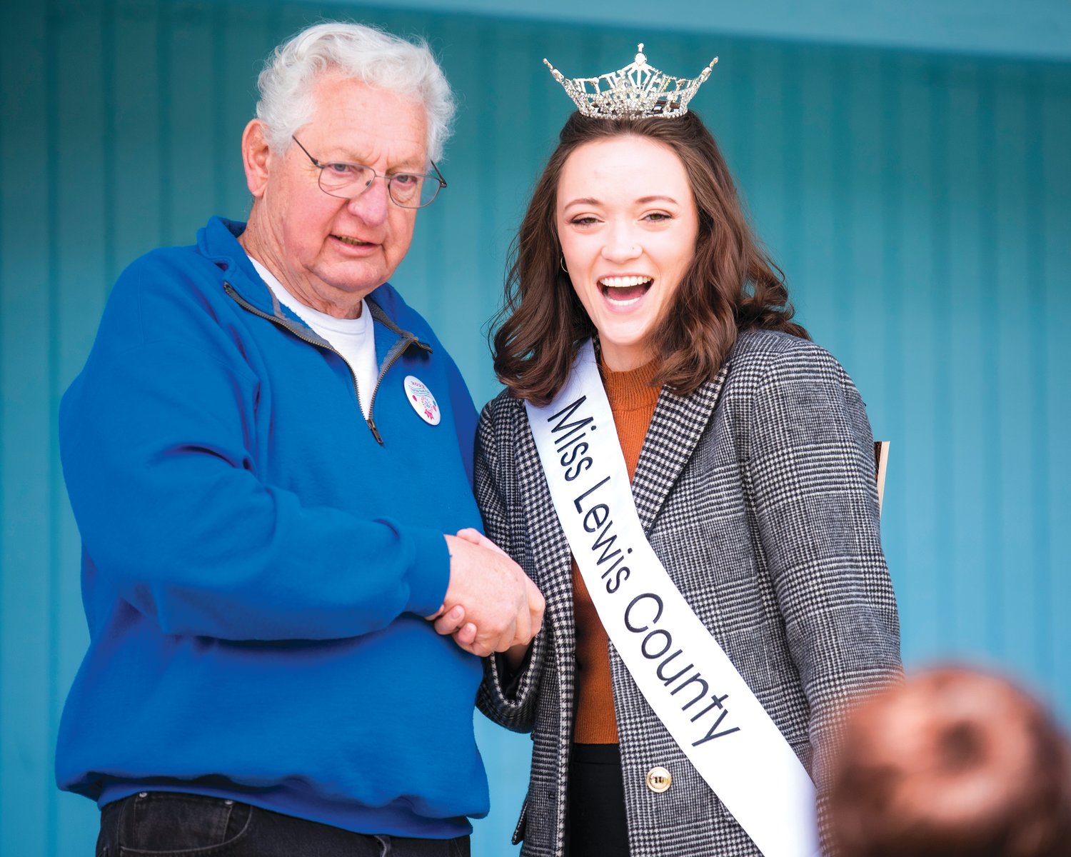 Lee Coumbs poses for a photo while shaking hands with Miss Lewis County Briana Rasku Sunday afternoon during the Spring Youth Fair in Centralia.