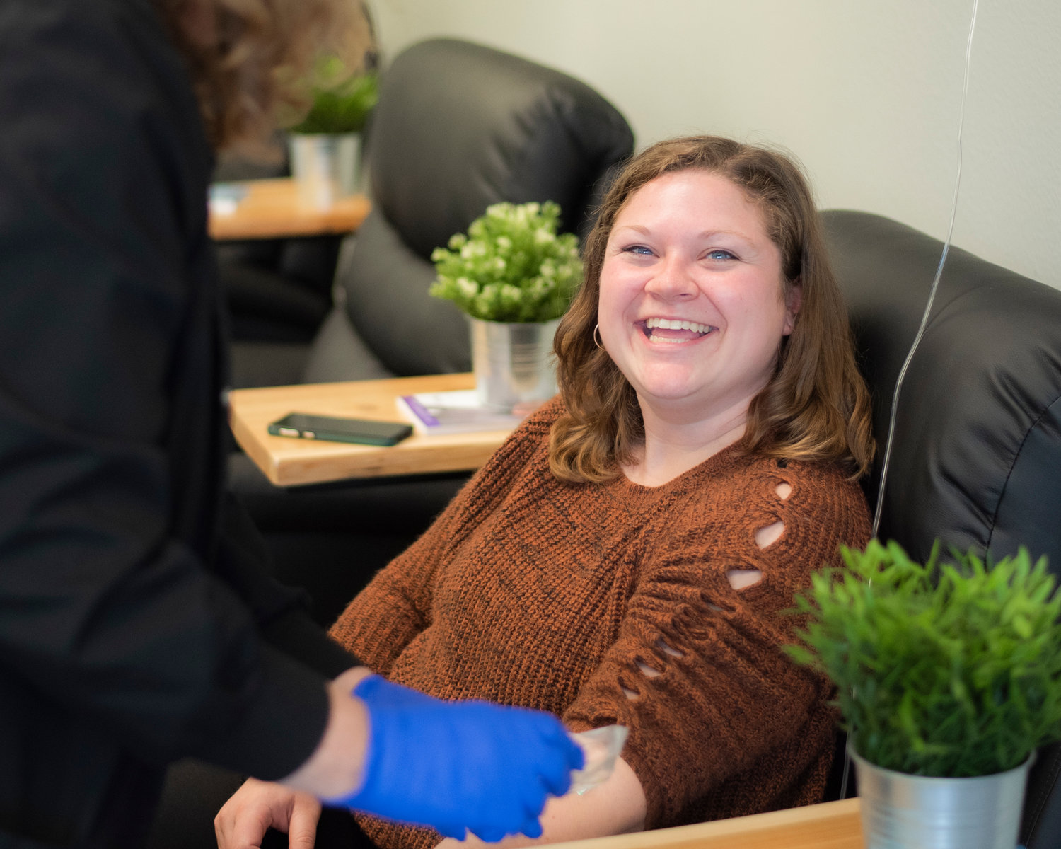 Office Manager Mikayla Rockey smiles while receiving an infusion Tuesday at Evexia Northwest in Centralia.