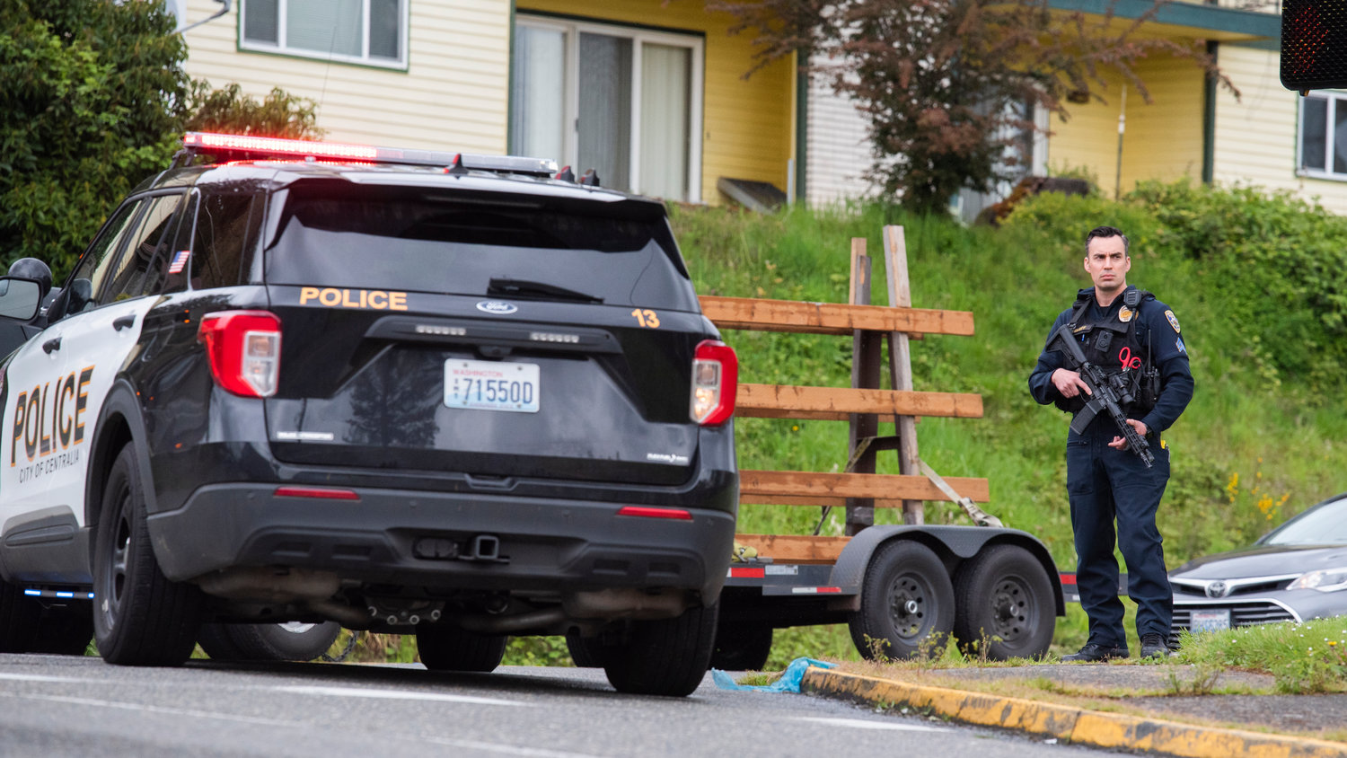Detective Sergeant David Clary with the Centralia Police Department stands with a weapon indexed near Southwest 13th Street in Chehalis as officers search for a suspect following a robbery in the 600 block of South Market Boulevard.