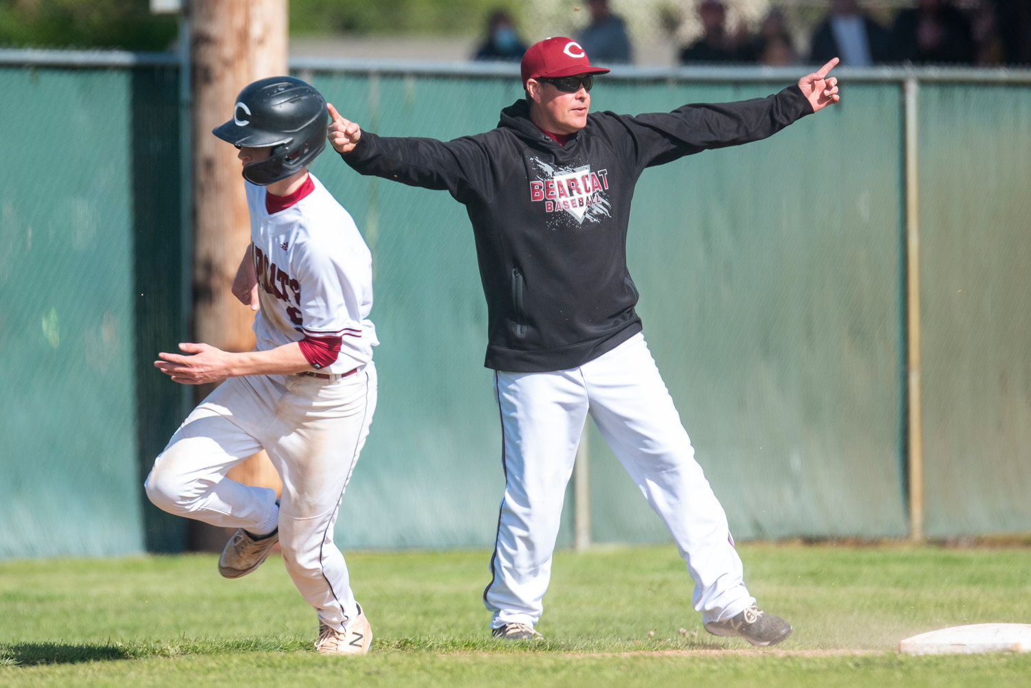 W.F. West coach Bryan Bullock waves Avery Staloh home during a district playoff win over Ridgefield on May 10.