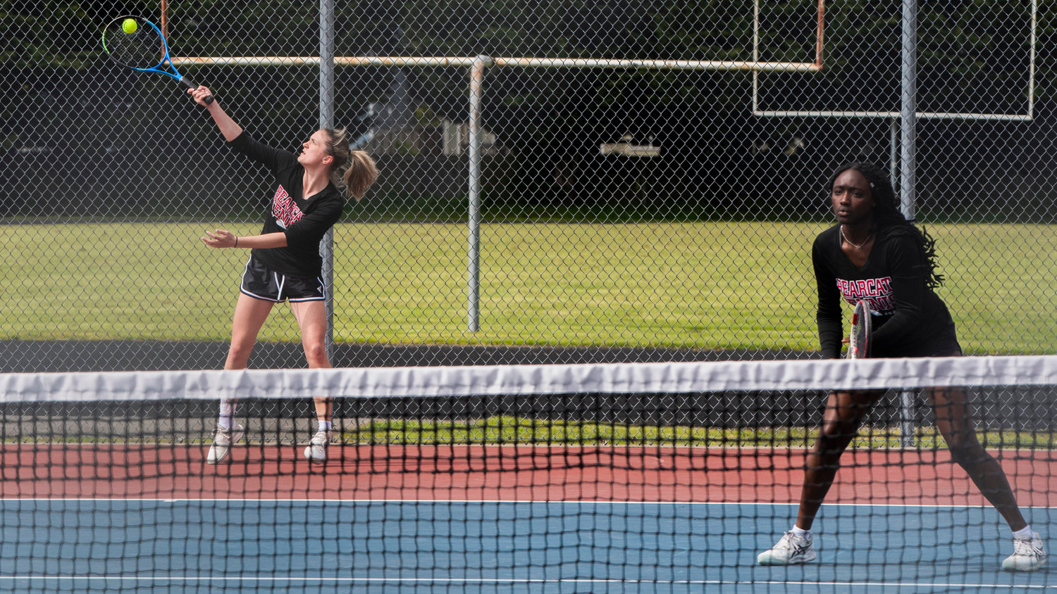 W.F. West’s Kaylynne Dowling serves up a shot alongside her partner Mariama Ceesay during a doubles match at A.G. West Black Hills High School Tuesday afternoon in Tumwater.