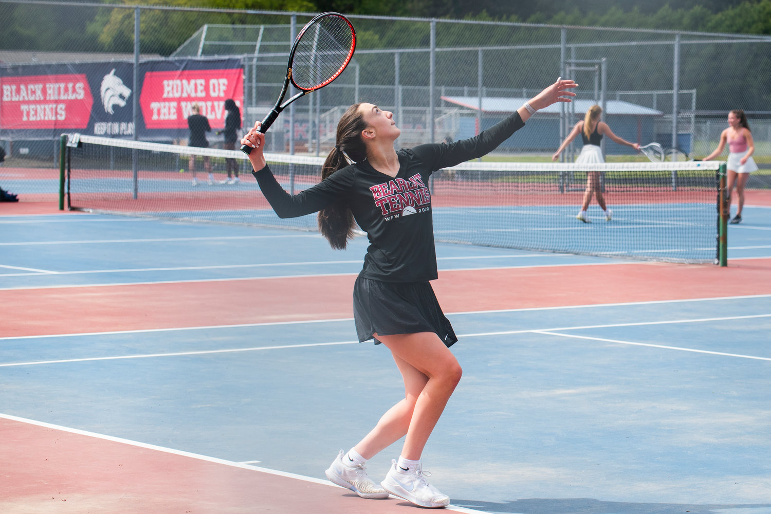 Claire Kuykendall, first singles player for W.F. West, looks up as she prepares to serve during a match at A.G. West Black Hills High School Tuesday afternoon in Tumwater.