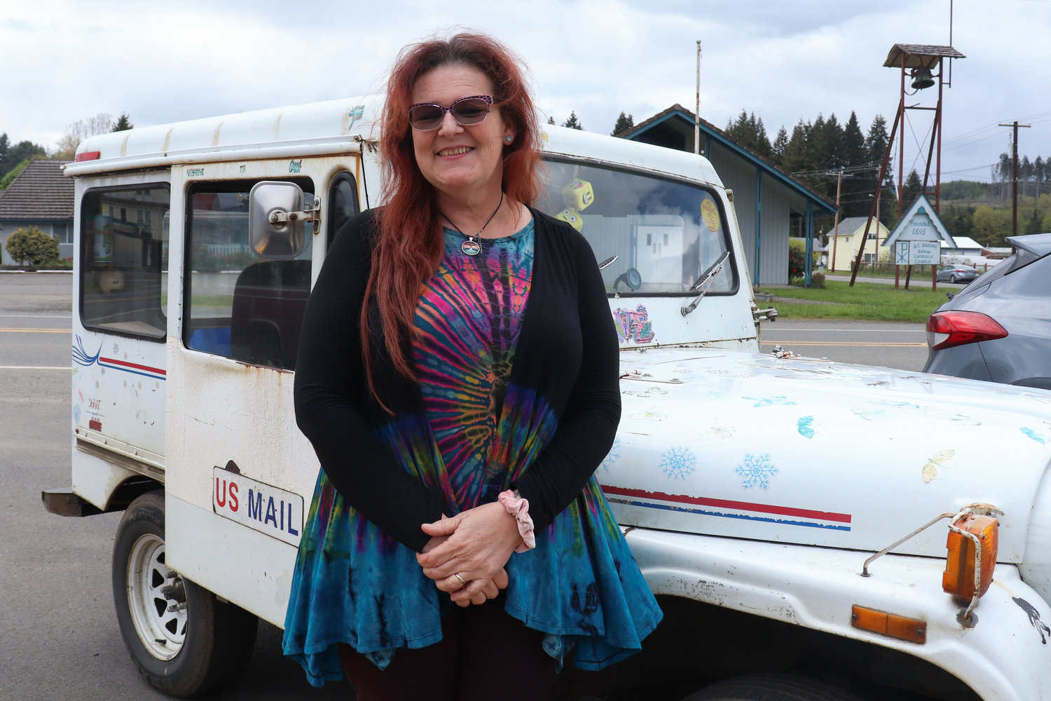 Lisa-Marie Wilson poses for a photograph beside one of her mail delivery vehicles in this photograph captured last week in Pe Ell.