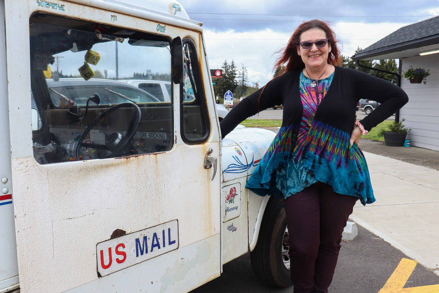Lisa-Marie Wilson poses for a photograph beside one of her mail delivery vehicles in this photograph captured last week in Pe Ell.