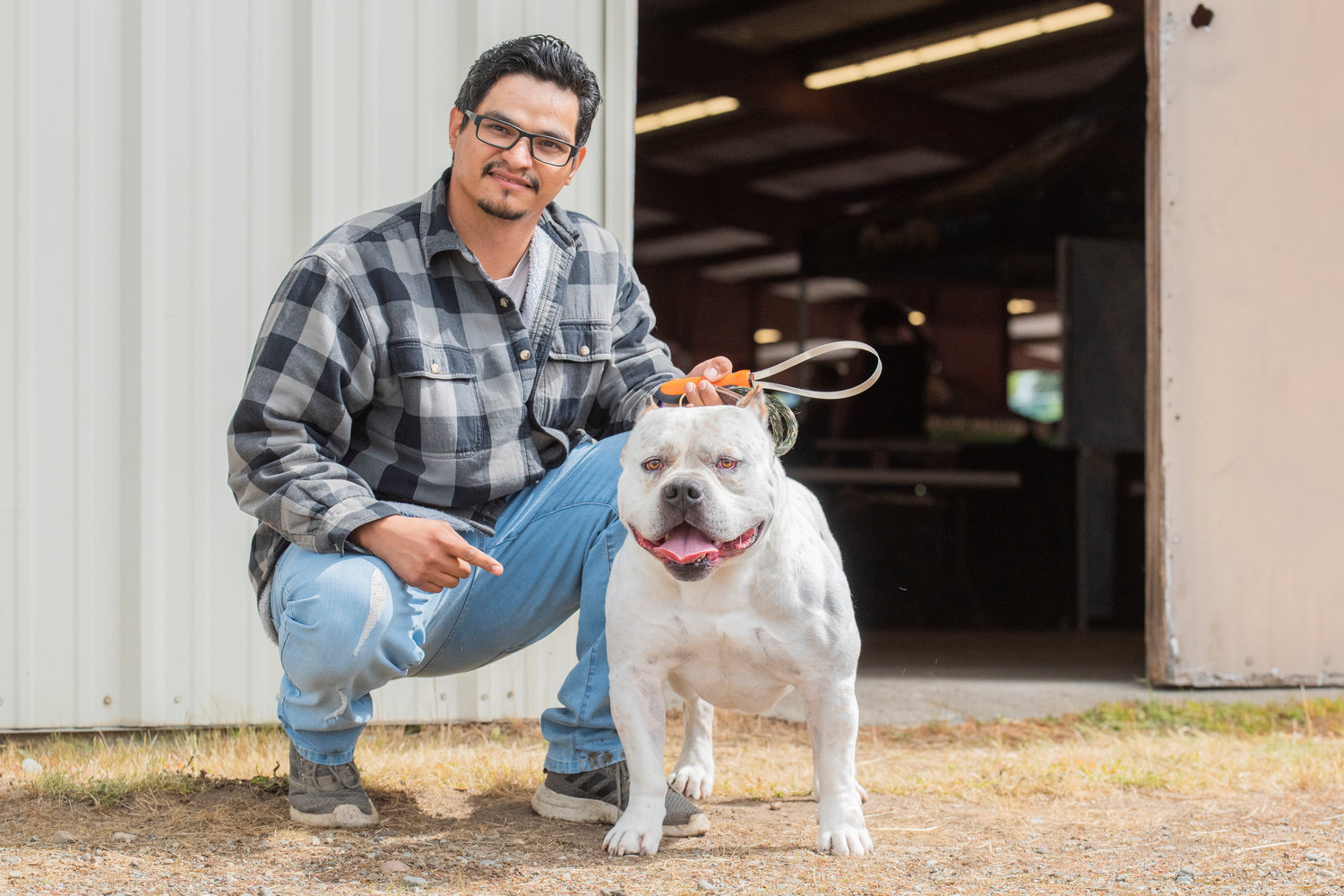 Luis Yanez poses for a photo with Bronx, an American Bully, at the Southwest Washington Fairgrounds Saturday morning.