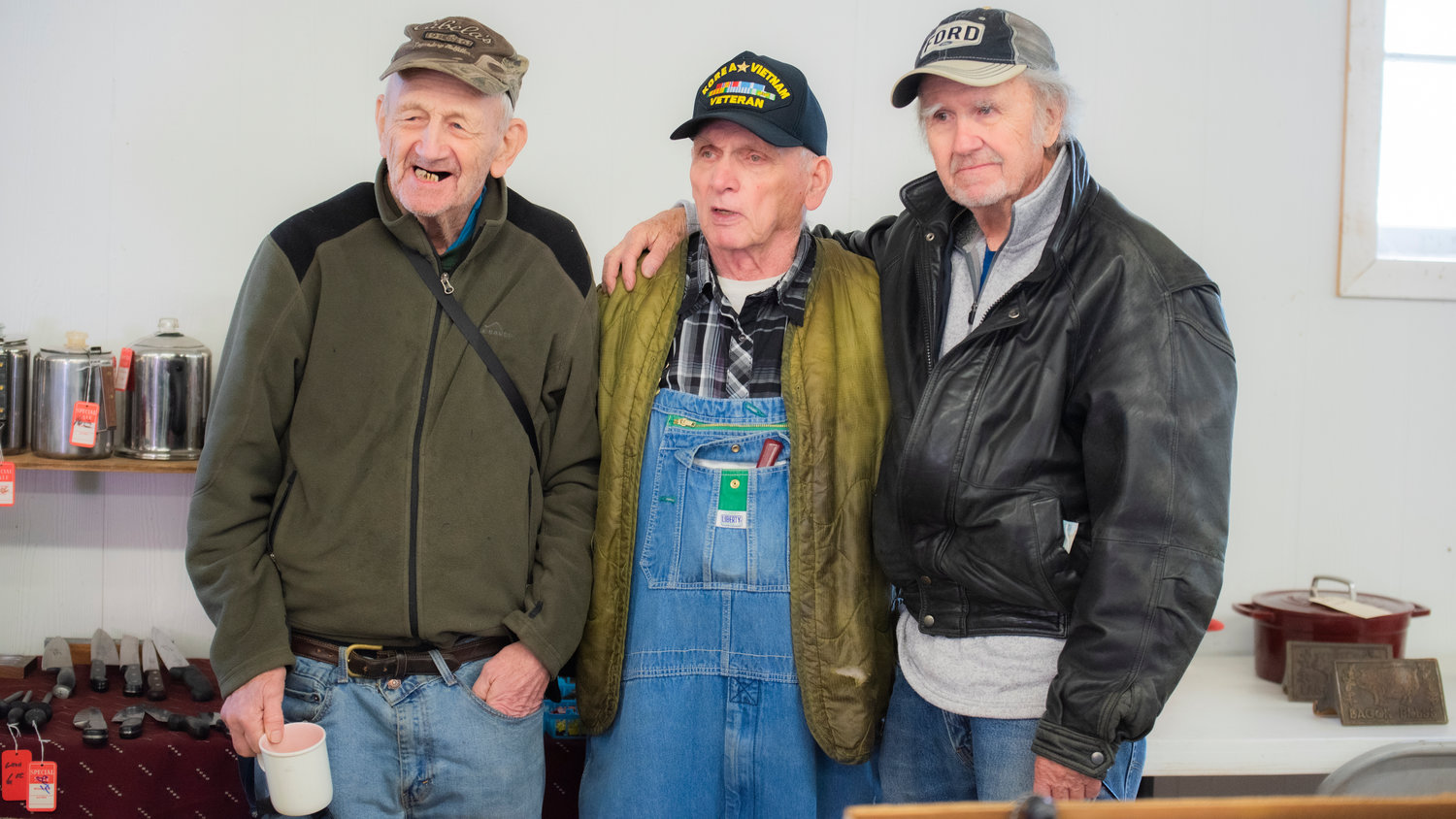 Burt Illig, 88, stands between fellow salesmen John Sheilds and Vern Webb during the Spring Community Garage Sale Saturday morning in Centralia. Illig is the oldest vendor and has been attending the garage sale at the Southwest Washington Fairgrounds for approximately 15 years as a vendor with help from his friends.