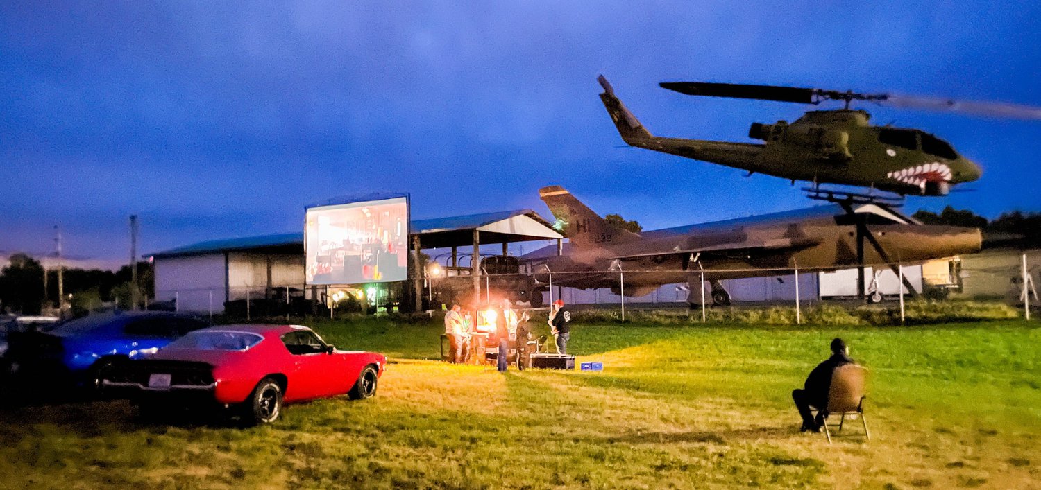 Vehicles park as attendees line up for popcorn in Chehalis while the movie “Seabiscuit” plays on a screen during an event hosted the Veterans Memorial Museum Saturday night.