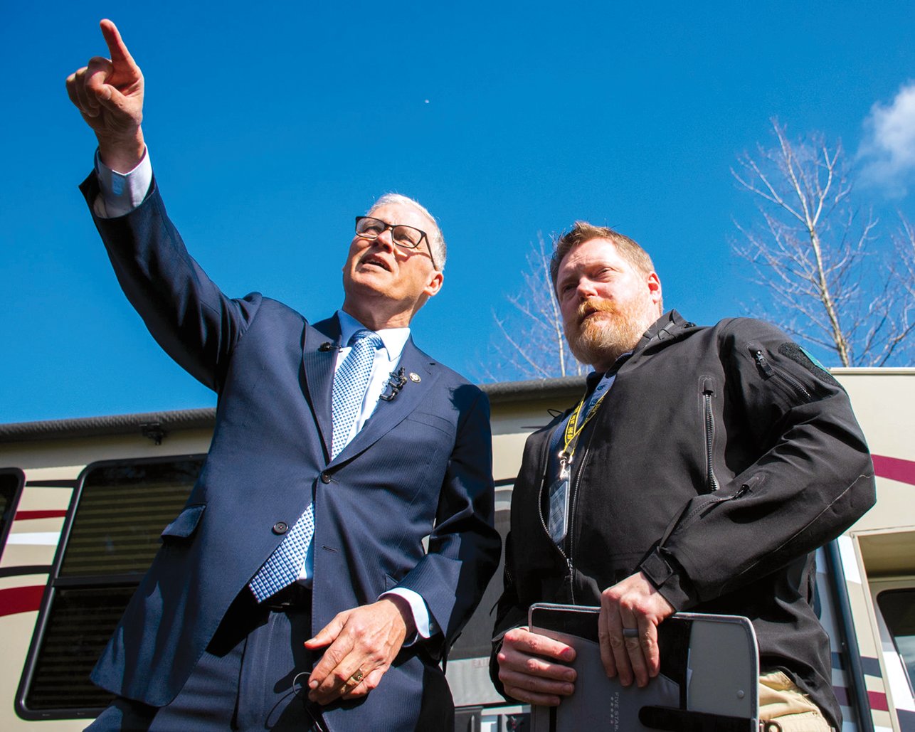 FILE PHOTO — Gov. Jay Inslee points to the isolation area of what at the time was considered a potential COVID-19 quarantine site during a tour with Washington State Department of Health Commander Nathan Weed at Maple Lane in March 2020.