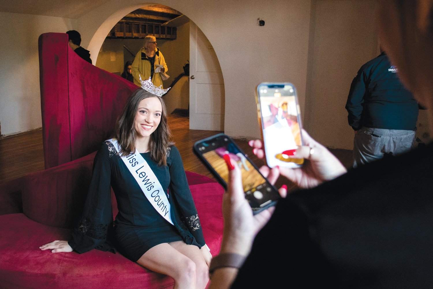 Miss Lewis County Briana Rasku poses for photos on a decorative couch during a Centralia-Chehalis Chamber of Commerce Business After Hours event and open house at the Fox Theater Thursday in Centralia.