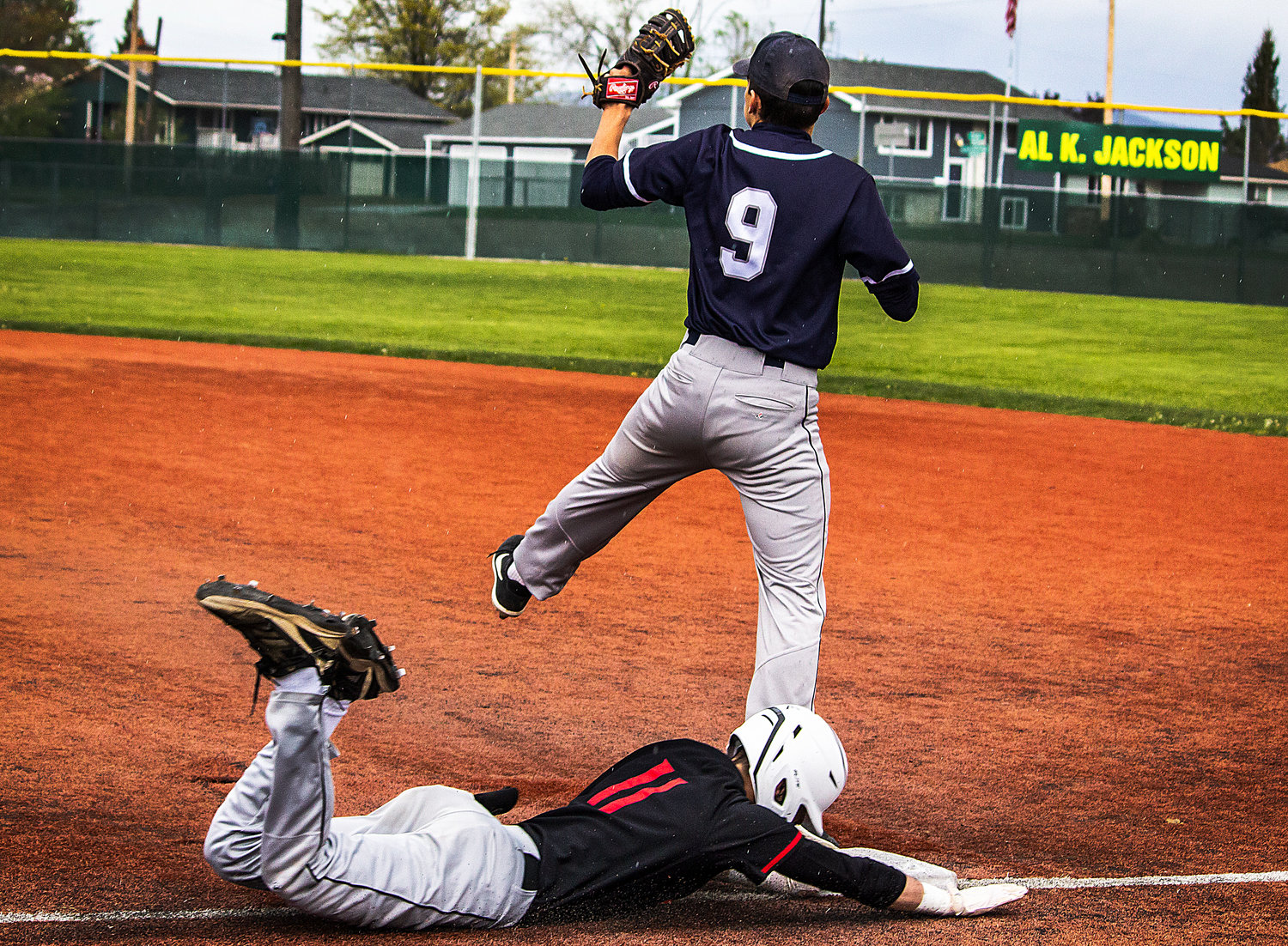 Toledo's Carson Gould slides into first base during WIAA State 2B Baseball action on Saturday, May 21, at Shadle Park High School in Spokane. Chewelah's Dekota Acosta was receiving the throw to first base.