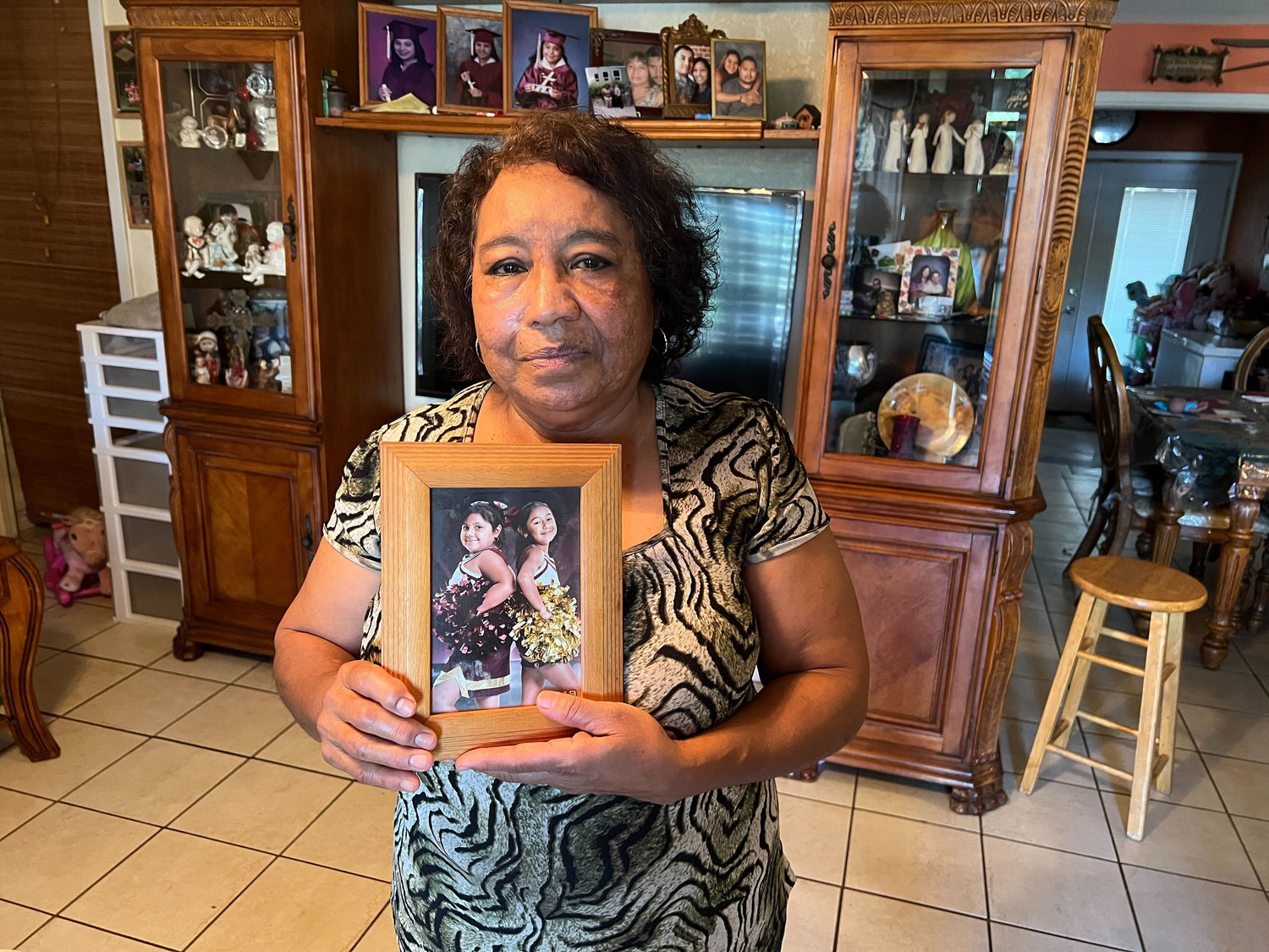 Nelda Lugo, 63, holds a photo of her, granddaughters Eliana Garcia, 9, left, and Janel Garcia, 11. Eliana was killed in the school shooting at Robb Elementary School in Uvalde, Texas. (Molly Hennessey-Fiske/Los Angeles Times/TNS)