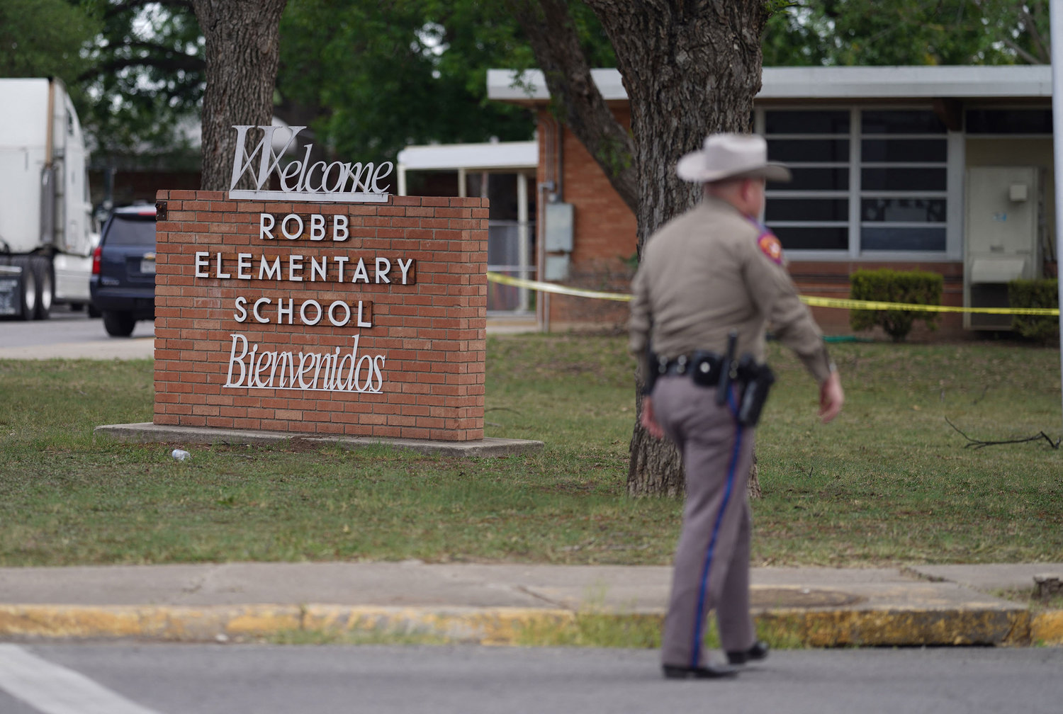An officer walks outside of Robb Elementary School in Uvalde, Texas, on Tuesday, May 24, 2022. An 18-year-old gunman killed 19 children and two adults at an elementary school in Texas on Tuesday, according to the state's governor, in the nation's deadliest school shooting in years. (Allison Dinner/AFP/Getty Images/TNS)