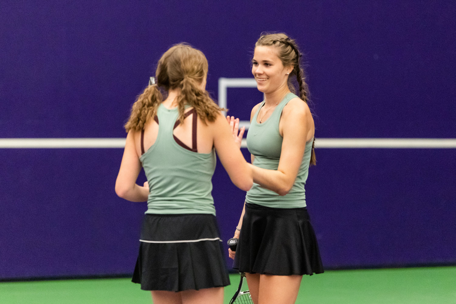Centralia's Elizabeth Hopkins (left) and Maddie Corwin (right) high-five during the first set of the 2A girls' doubles tennis state competition on May 27, 2022.