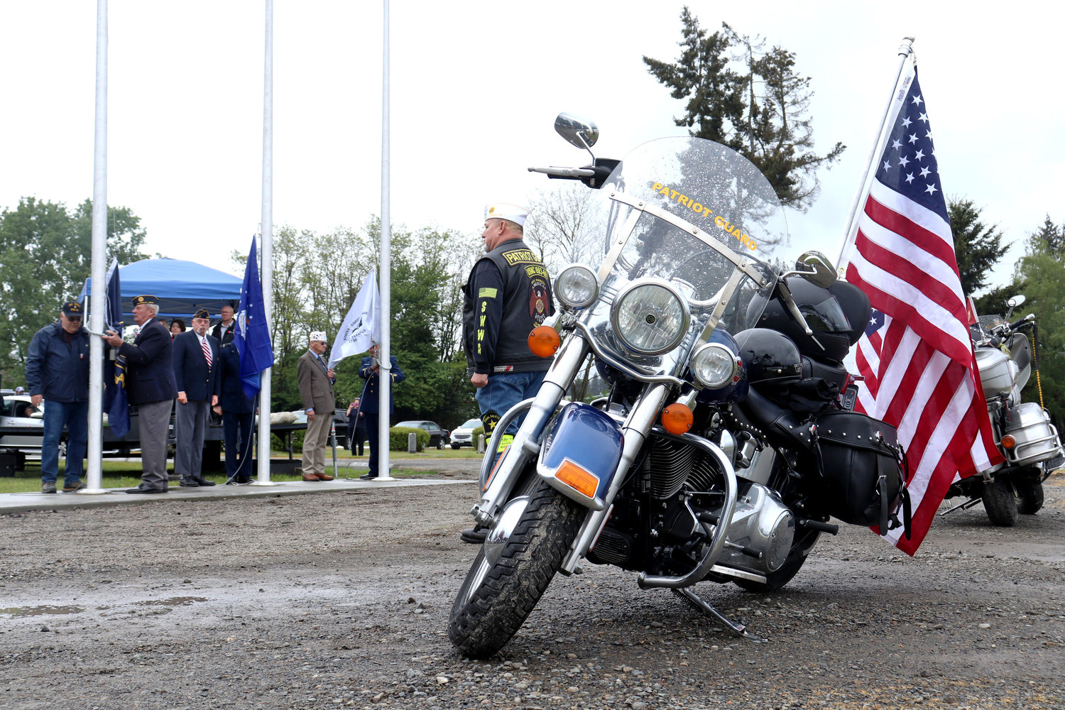 Patriot Guard riders with Post 25 American Legion stand at attention while members of a military honor guard and American Legion Post 17 raise flags for their respective branches at Sticklin Greenwood Memorial Park during a rededication ceremony on Saturday.