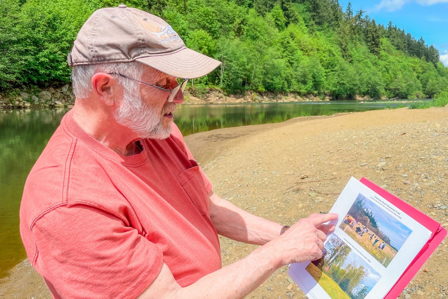 Don Watt, secretary with the Chehalis River Basin Land Trust, points out photos from youth projects inside the Centralia Discovery Park.