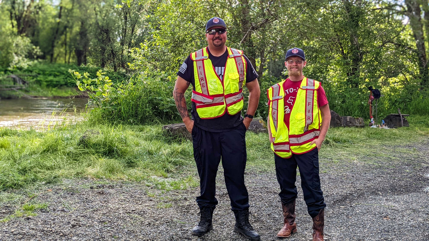 Jeremy Anderson and Cory Antony from Grays Harbor Fire District 1 smile for a photo on Saturday in front of the Chehalis River at Oakville after rescuing a man whose canoe tipped.
