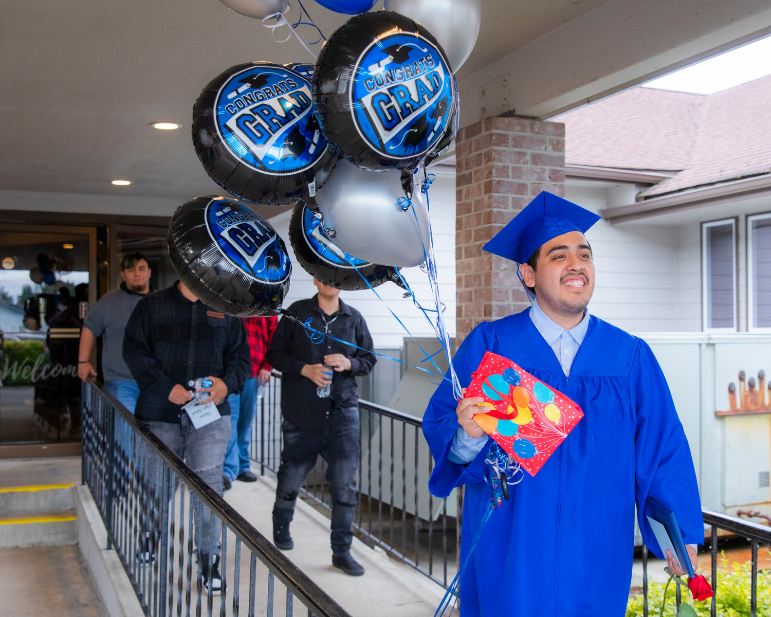 Fernando Moreno-Perez smiles as he walks outside with his diploma and balloons following a graduation ceremony for Futurus High School Tuesday in Centralia.