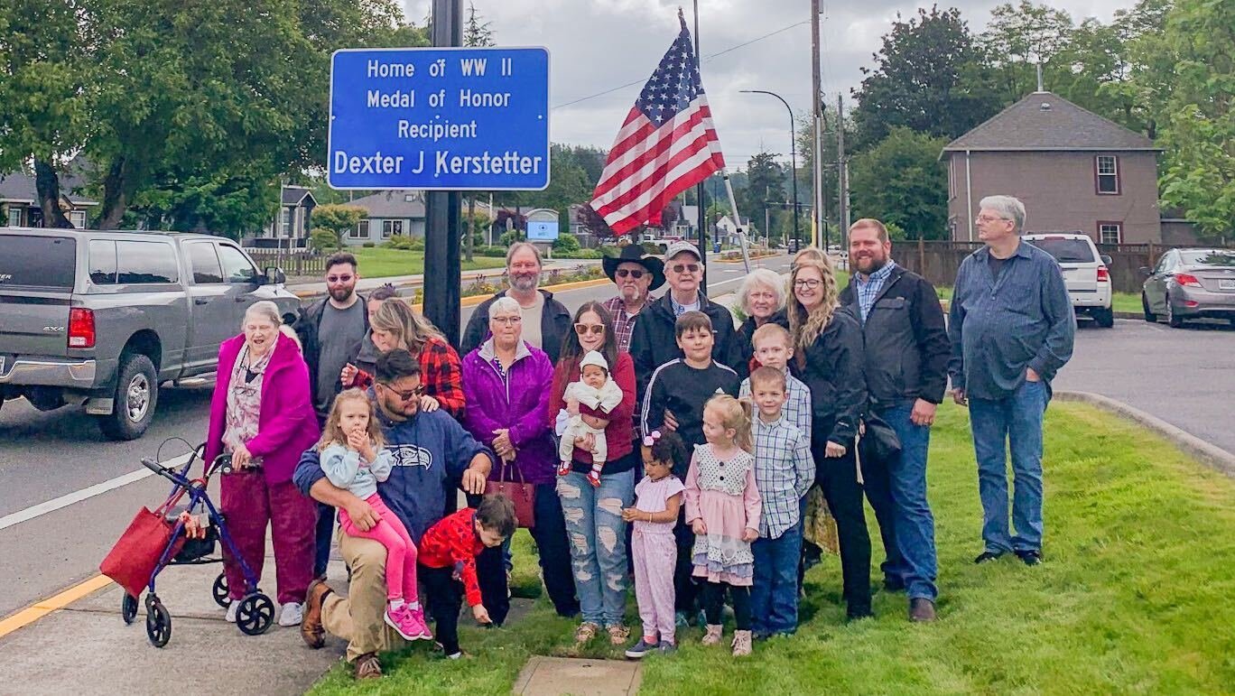 Members of Dexter Kerstetter’s family gather under the sign dedicated to their relative.