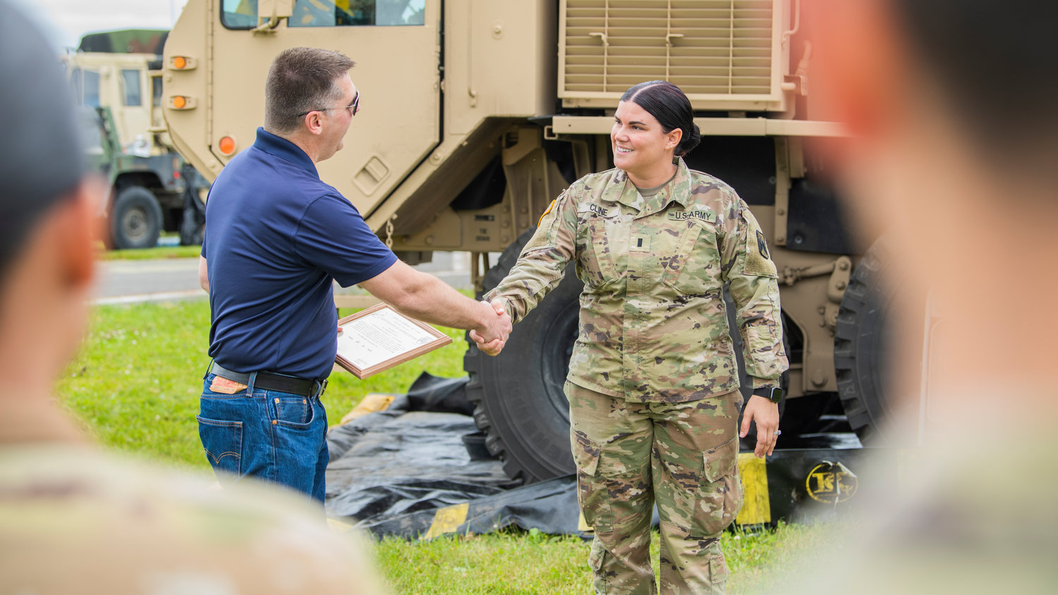 Brandon Rakes is recognized with a certificate of appreciation from Apollo Company as he shakes hands with United States Army First Lieutenant Savannah Cline at the Chehalis-Centralia Airport during a military training exercise Wednesday in Chehalis.