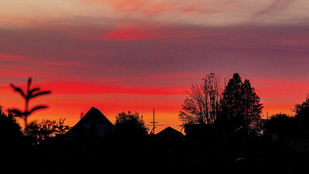 The sunset fades over barns and homes on Crego Hill in Adna on Tuesday evening, the longest day of the year.