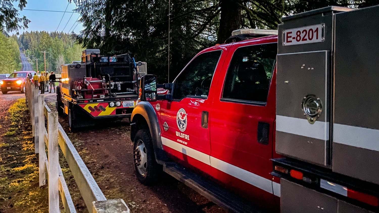 Department of Natural Resources Wildfire crews are seen along McAuley Avenue off Brockway Road while responding to a fire West of Chehalis Sunday evening.