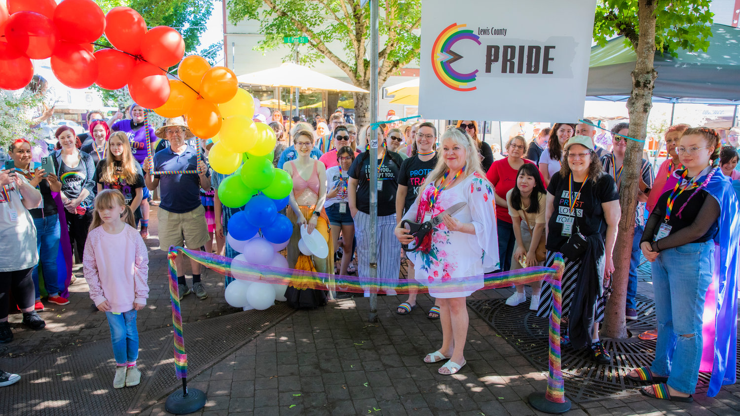 Hope Schumacher smiles for a photo as she prepares to cut a ribbon Saturday morning to mark the beginning of a pride event in downtown Centralia after honoring the life of Rikkey Outumuro, known to many as Tru Starlet.