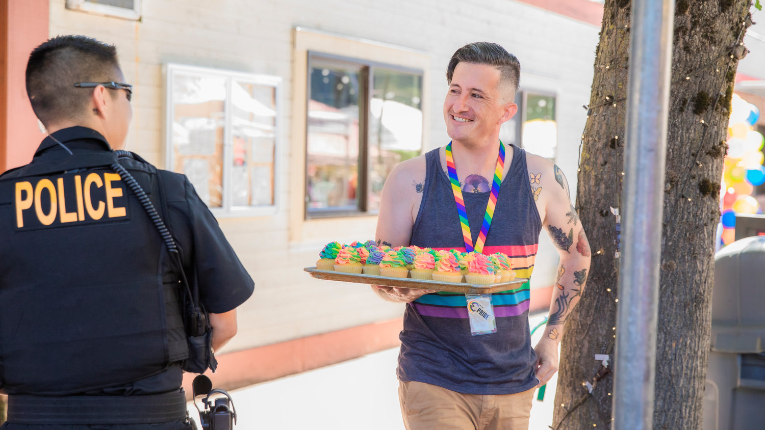Kyle Wheeler smiles while handing out rainbow-colored cupcakes Saturday morning during a pride event in downtown Centralia. The cupcakes are a tradition Wheeler started to honor a close friend, Kali, who died in 2019.