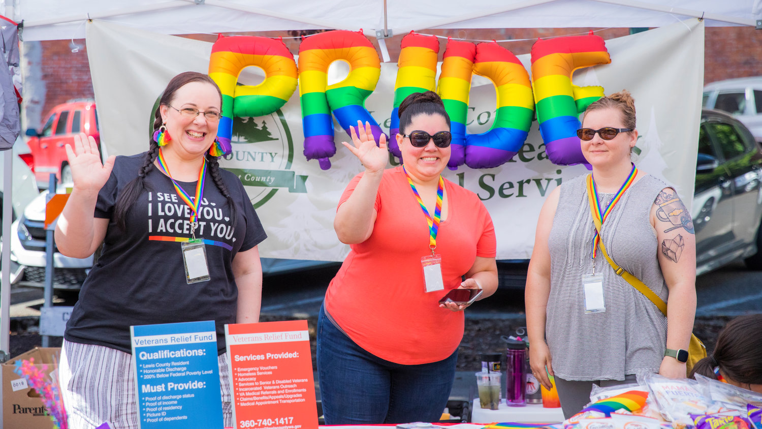 Lewis County Public Health and Social Services employees wave during a pride event in downtown Centralia Saturday morning.