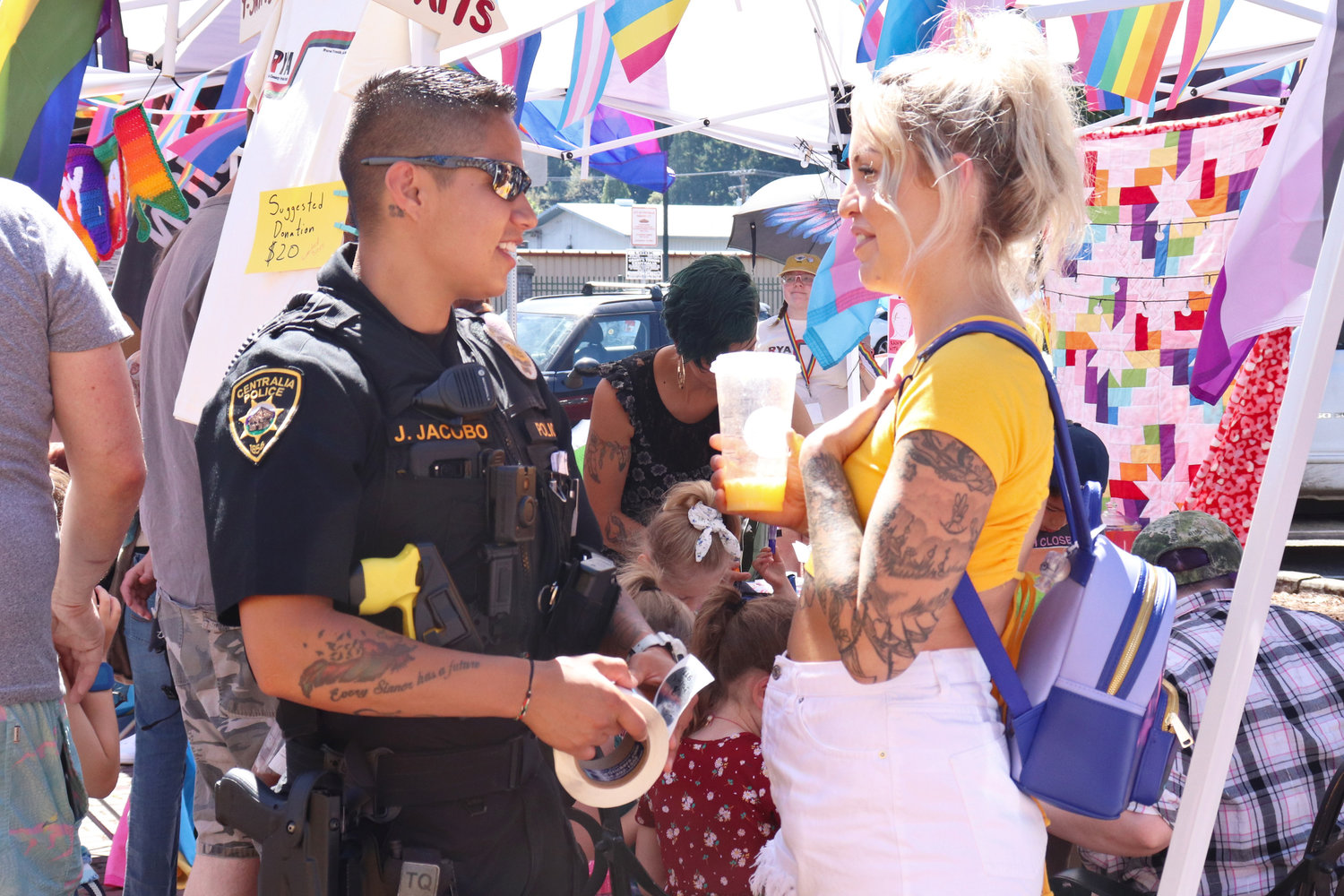 Officer Julie Jacobo with the Centralia Police Department passes out stickers alongside her wife, Kalyn Jacobo, during Lewis County Pride in Centralia on Saturday.